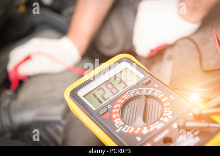 Automechaniker verwendet ein Multimeter auto Batteriespannung prüfen Stockfoto