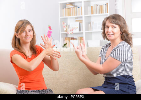 Lächelnd taube Frau lernen Gebärdensprache und sprechen mit ihrem Lehrer Stockfoto