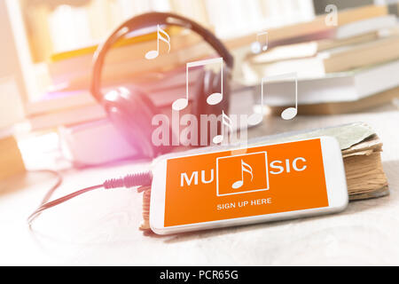 Handy mit Musik Anwendung auf einem Display mit Kopfhörer gewinnen Hintergrund auf dem Tisch Stockfoto