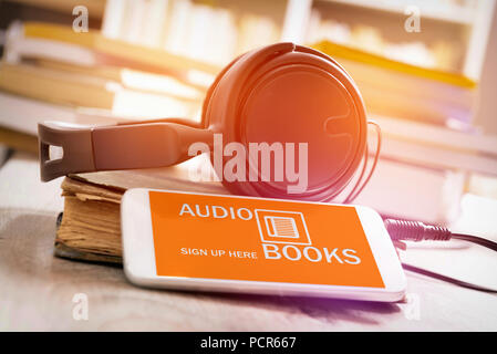 Smart Phone mit Audio Bücher Anwendung auf dem Bildschirm, der Kopfhörer und des Bücher aus Papier. Konzept der Hörbücher zu hören. Stockfoto