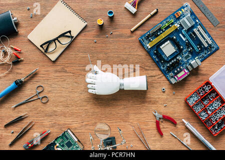 Draufsicht der prothetischen Arm holding Schraubendreher auf Tabelle mit Tools Stockfoto