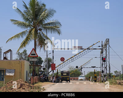 Die Barrieren absteigend an einem Bahnübergang in ländlichen Karnataka, Indien