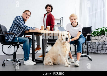 Junge start-up Team und Hund von der Kamera im Büro suchen Stockfoto