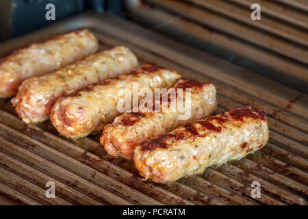 Cevapcici gebacken auf dem Grill. Kleine Würstchen aus Hackfleisch/Faschiertem, ein sehr beliebtes Gericht in den Balkanländern. Stockfoto