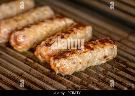 Cevapcici gebacken auf dem Grill. Kleine Würstchen aus Hackfleisch/Faschiertem, ein sehr beliebtes Gericht in den Balkanländern. Stockfoto