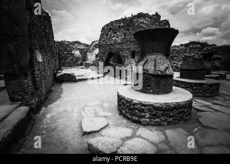 Mühlen und eine gemauerte Lehmofen im Haus der Bäcker, der Casa del Forno, einer alten Bäckerei in der antiken Stadt Pompeji, in der Nähe von Neapel, Italien Stockfoto