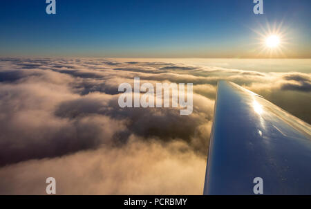 Die Bewölkung über Winterberg mit der rechten Flugzeugflügel, Sonnenuntergang, blauer Himmel, Hochsauerland (Kreis), Nordrhein-Westfalen, Deutschland Stockfoto