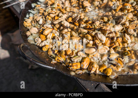 Frische Muscheln im Grill Pfanne. Seafood Grill im Freien. Picknick gesundes Essen, Muscheln ohne Schale. Fisch, Gegrilltem appetitlich Muscheln auf einer schwarzen Platte Stockfoto