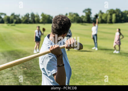 Teenage afrikanische amerikanische Junge spielt Baseball mit Freunden im Park Stockfoto