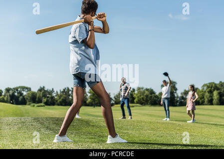 Afrikanische amerikanische Teenager holding Baseball Schläger und spielen mit Freunden im Park Stockfoto