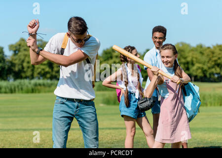 Lächelnd jugendliche Spaß haben und spielen Baseball in Park Stockfoto