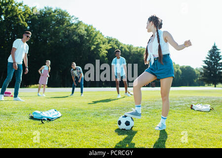 Happy teenage multiethnischen Freunde spielen mit Fußball im Park Stockfoto