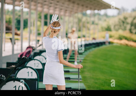 Rückansicht des weiblichen Golfspieler mit Golf Club gruss Freund am Golfplatz Stockfoto
