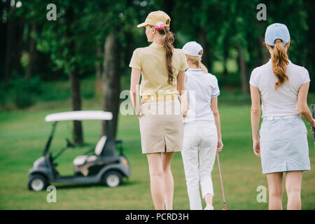 Ansicht der Rückseite des Frauen mit Golf gear Wandern auf grünen Rasen am Golfplatz Stockfoto