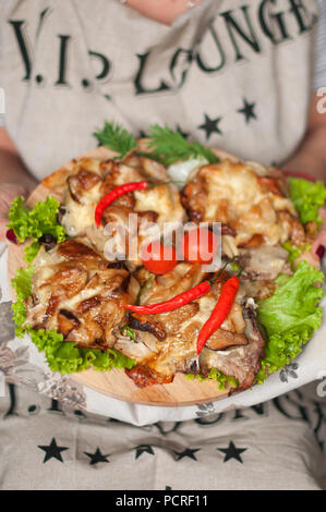 Gebackenes Huhn auf einer großen Platte. in den Händen von Essen. Nützliche Abendessen. gesunde Ernährung Stockfoto