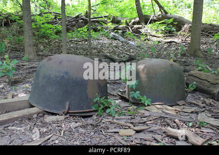 Riesige Kessel im Eisenkessel, die kopfüber auf dem Boden im Wald gelagert wurden. Stockfoto