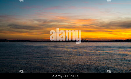 Die Freiheitsstatue, in der Glut der Ein wunderschönes Winter sunett allein in der clam Stille des Hudson River, NEW YORK CITY, USA das Aalen. Stockfoto