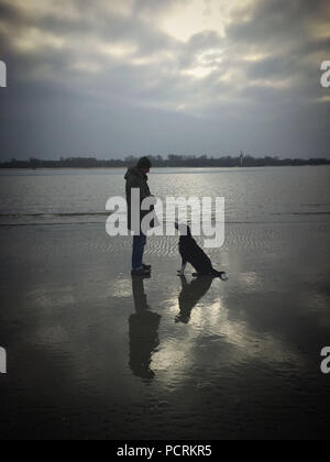 Mann mit Hund durch den Fluss Stockfoto