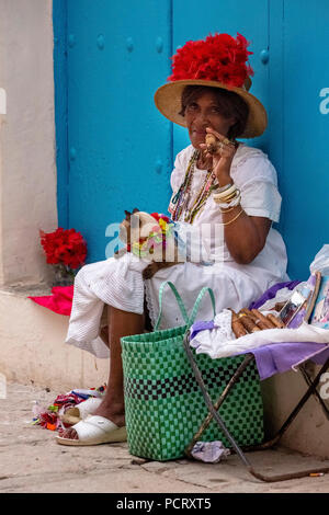 Alte kubanische Frau raucht eine kubanische Zigarre auf der Straße und wirft mit ihrer Katze für die Touristen, La Habana, Kuba, Karibik, Zentralamerika, La Habana, Kuba Stockfoto