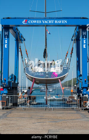 Eine große Racing Yacht aus dem Wasser gehoben wird in Cowes Yacht Haven auf der Isle of Wight mit einem Boot hoist in der Marina. Stockfoto