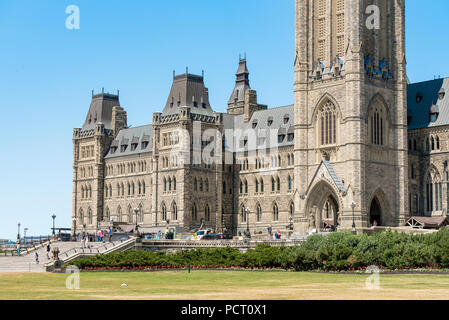 Ottawa, Ontario, Kanada. House of Commons neben Peace Tower, Zentrum Gebäude auf dem Parliament Hill, gegen den blauen Himmel im Sommer. Stockfoto
