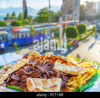 Die besten Döner besteht aus den Schichten von duftenden gebratenen beaf mit warmen Fladenbrot, frisches Gemüse und Pommes frites in open Air Cafe von Antalya. Stockfoto