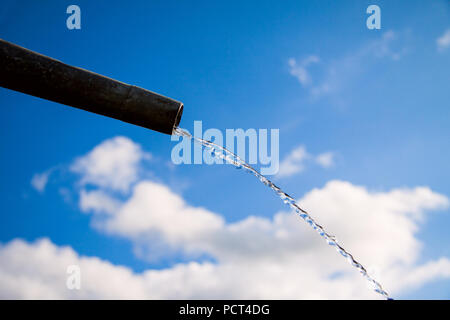 Tropfen Wasser aus Rohr - Nahaufnahme mit blauem Himmel. Konzept für die Wassermangel- und Umweltfragen. Kopieren Sie Platz zum Schreiben. Stockfoto