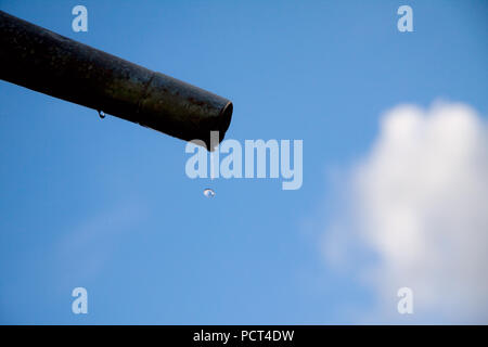 Tropfen Wasser aus Rohr - Nahaufnahme mit blauem Himmel. Konzept für die Wassermangel- und Umweltfragen. Kopieren Sie Platz zum Schreiben. Stockfoto