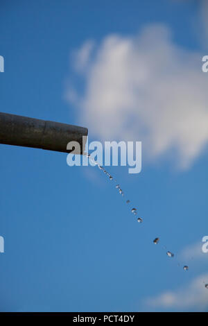 Tropfen Wasser aus Rohr - Nahaufnahme mit blauem Himmel. Konzept für die Wassermangel- und Umweltfragen. Kopieren Sie Platz zum Schreiben. Stockfoto