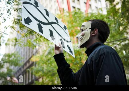 Demonstrant Tragen eines V für Vendetta Guy Fawkes Maske. Besetzt die Wall Street Protest und Bewegung, im Zuccotti Park, Wall Street New York. Stockfoto