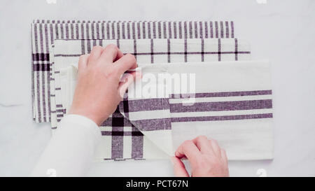 Klappbare Blck und weiß gemusterten Papier Handtücher auf Marmor Oberfläche. Stockfoto