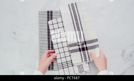 Klappbare Blck und weiß gemusterten Papier Handtücher auf Marmor Oberfläche. Stockfoto