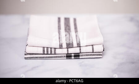 Klappbare Blck und weiß gemusterten Papier Handtücher auf Marmor Oberfläche. Stockfoto