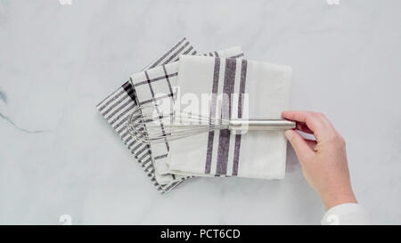 Klappbare Blck und weiß gemusterten Papier Handtücher auf Marmor Oberfläche. Stockfoto