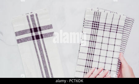 Klappbare Blck und weiß gemusterten Papier Handtücher auf Marmor Oberfläche. Stockfoto