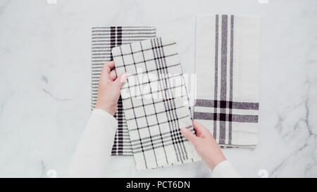 Klappbare Blck und weiß gemusterten Papier Handtücher auf Marmor Oberfläche. Stockfoto