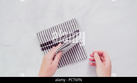 Klappbare Blck und weiß gemusterten Papier Handtücher auf Marmor Oberfläche. Stockfoto