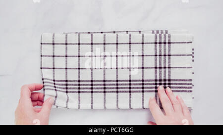 Klappbare Blck und weiß gemusterten Papier Handtücher auf Marmor Oberfläche. Stockfoto