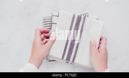 Klappbare Blck und weiß gemusterten Papier Handtücher auf Marmor Oberfläche. Stockfoto