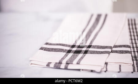 Klappbare Blck und weiß gemusterten Papier Handtücher auf Marmor Oberfläche. Stockfoto