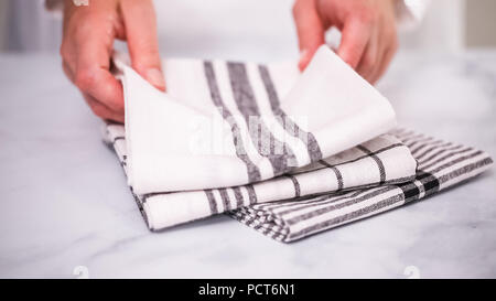 Klappbare Blck und weiß gemusterten Papier Handtücher auf Marmor Oberfläche. Stockfoto