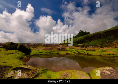 Dies ist ein Bild von Rocky River Bed einer hügeligen Fluss mit Wolken Hintergrund und Reflektionen auf dem Wasser. Stockfoto