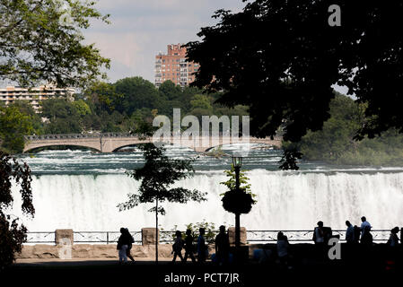 Niagara Falls, NY, USA. Oben auf die amerikanischen Fälle im Sommer wie von einem kanadischen Seite Suche gesehen, Vordergrund Silhouetten. Stockfoto