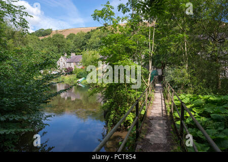 Fußgängerbrücke über den Fluss Wye an Litton Mühle in der Nähe Buxton in Derbyshire, England. Einen schönen Peak District Lage beliebt bei Wanderern. Stockfoto