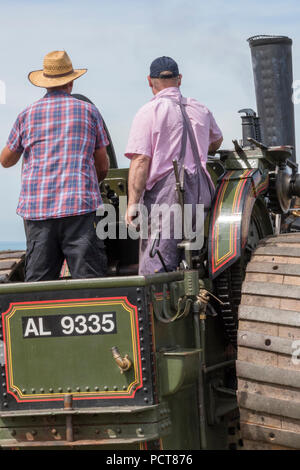 Zwei ältere Männer oder fahren eine große Zugmaschine Dampf angetriebene Fahrzeug oder Dampfwalze bei einem landwirtschaftlichen zeigen. Stockfoto