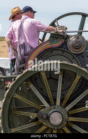 Zwei ältere Männer oder fahren eine große Zugmaschine Dampf angetriebene Fahrzeug oder Dampfwalze bei einem landwirtschaftlichen zeigen. Stockfoto