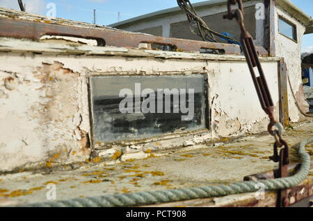 Heswall Boot Friedhof, verlassenen Boot im Schlamm stecken auf dem Dee Estuary auf dem Wirral in der Nähe von sheldrakes mit einem geisterhaften Spiegelbild im Fenster Stockfoto