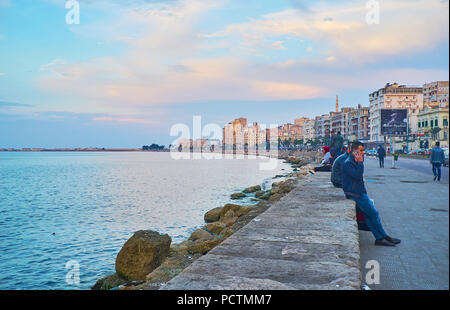 ALEXANDRIA, Ägypten - Dezember 18, 2017: Der Abend ist schön Zeit für eine Familie zu Fuß von Treffen mit Freunden in der Strandpromenade Corniche - die freudige Plac Stockfoto