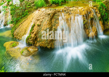 Die winzigen Herbst Kursunlu Waerfall von Cascade, Stretching entlang der schmalen Canyon mit großen Felsbrocken und schattigen Wald, Aksu, Türkei. Stockfoto