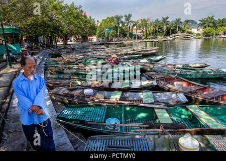 Asiatischer Mann hält auf die Boote im Morgenlicht auf Tam Coc, Vietnam Stockfoto